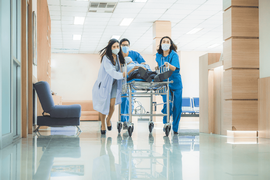 Emergency medical team rushing a patient on a stretcher through a hospital corridor, highlighting the impact of addiction-related emergencies in Mesa, Arizona in 2025.