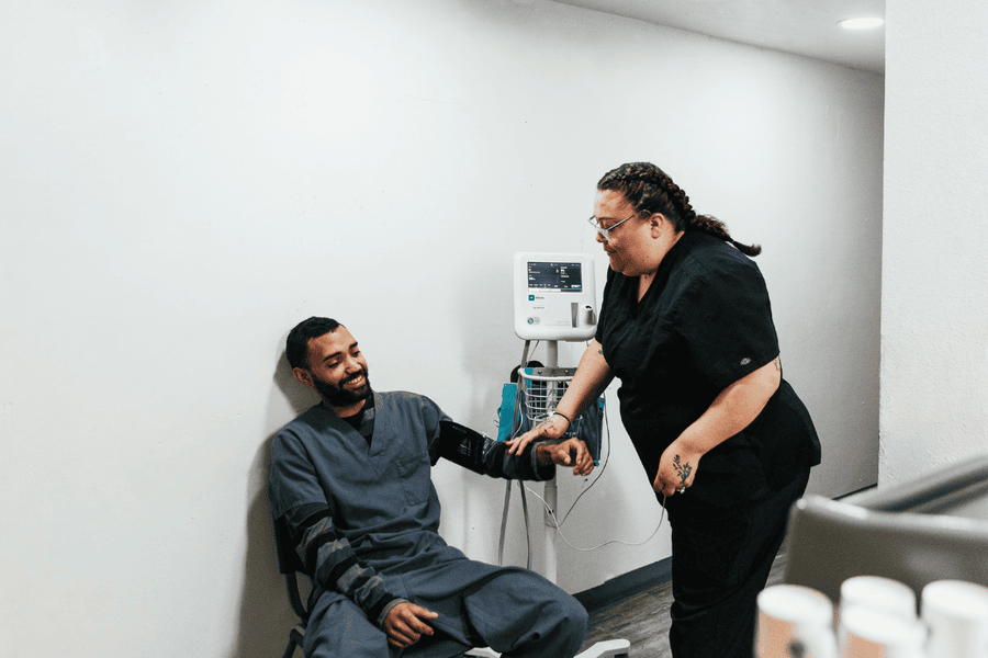 Healthcare professional at Axiom Care taking a patient’s blood pressure, providing compassionate support during alcohol detox treatment.