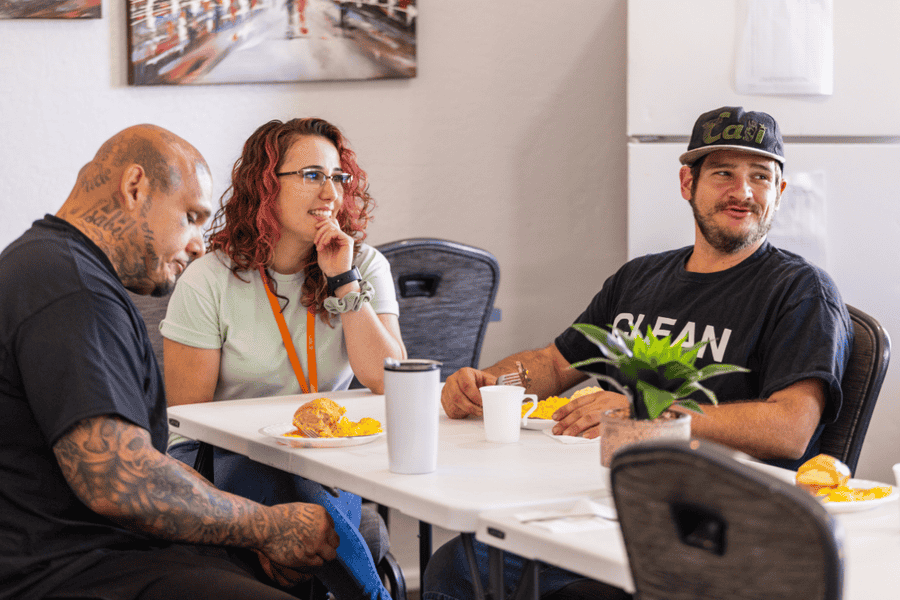 Individuals in recovery at Axiom Care sharing a meal and conversation, highlighting the importance of community support in managing meth withdrawal symptoms.