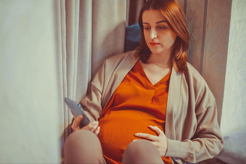 Pregnant Woman Checking Phone for Updates
