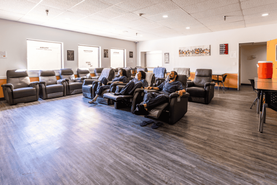 Patients in recliner chairs relaxing in a comfortable recovery lounge at Axiom Care, receiving care and support during detox.