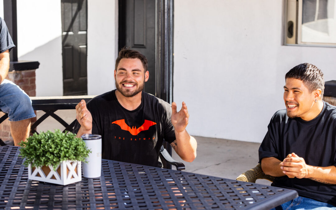 Man smiling while enjoying time with friends in recovery at an Axiom Care location.
